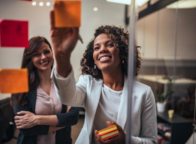 Businesswomen brainstorming with post-it notes