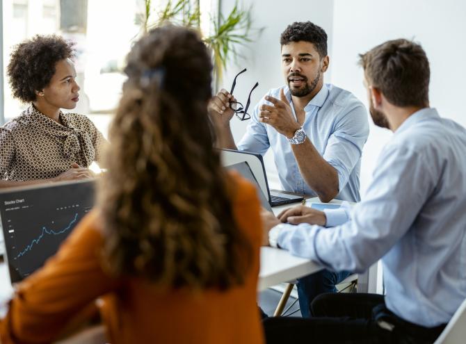 Group of people sitting in an office discussing something